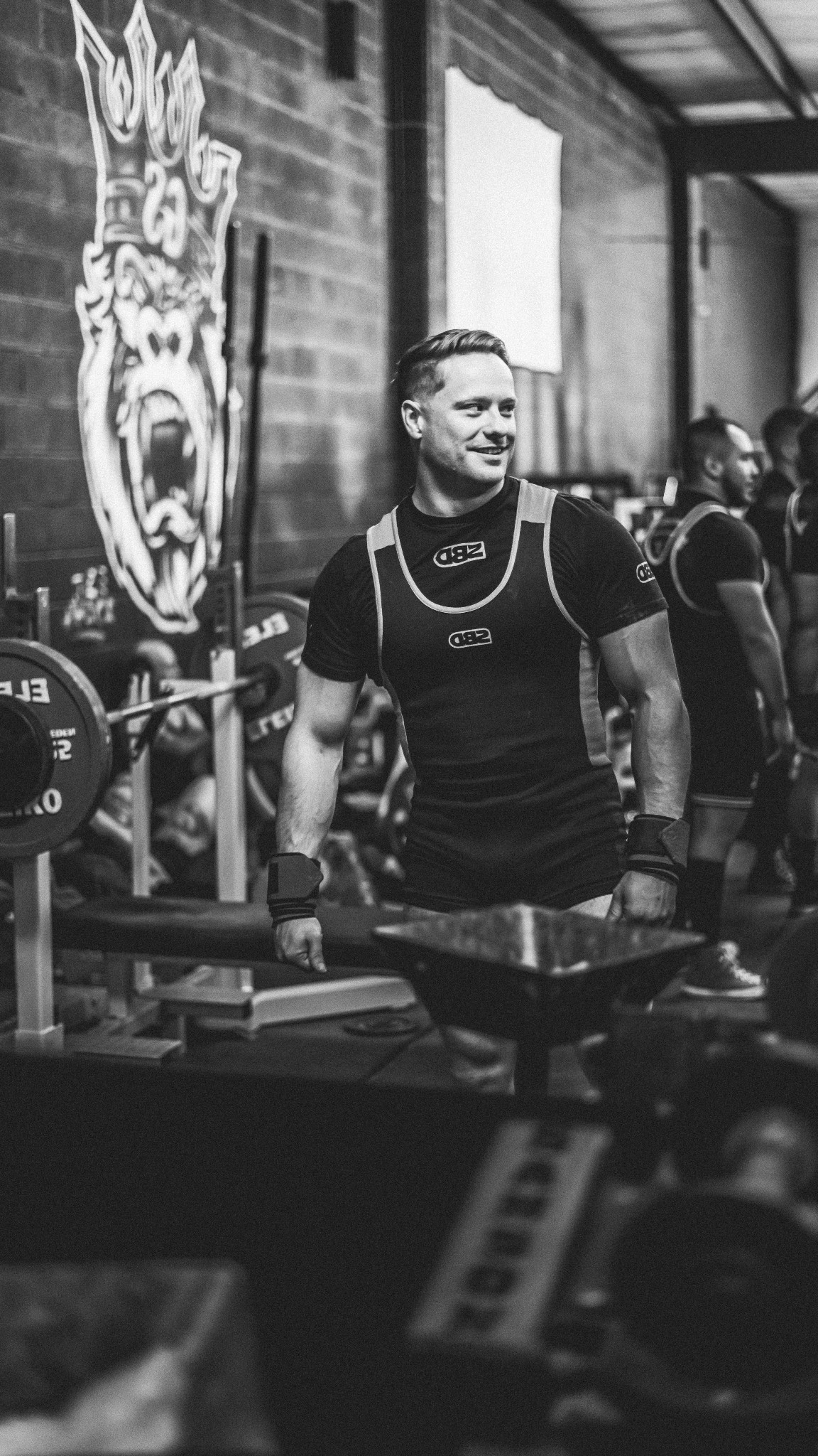 Daniel standing in a gym in powerlifting apparel.
